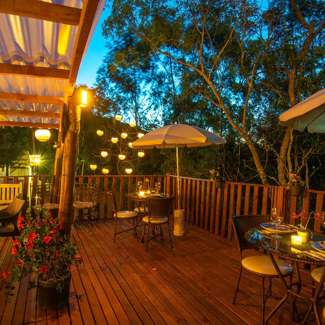 Deck Rústico iluminado ao entardecer, cercado de árvores